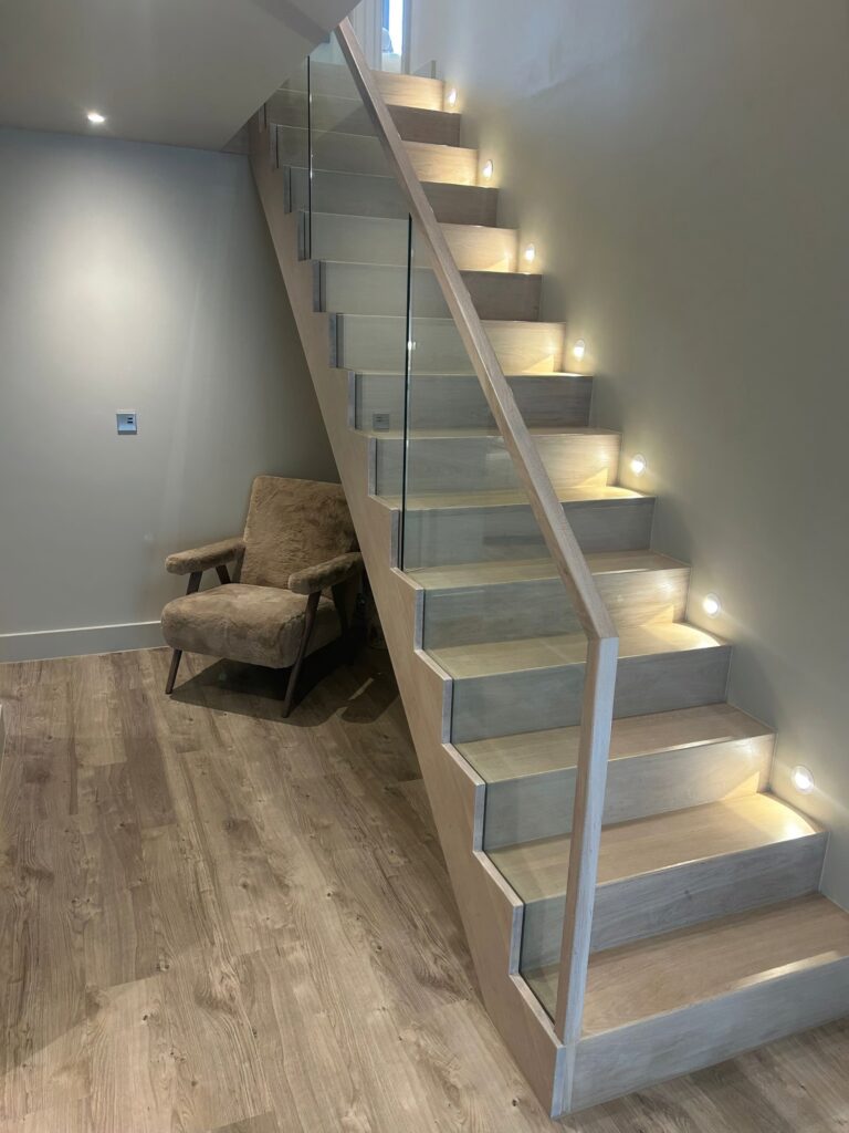 Contemporary Staircase Light Ash Grey With Glass Balustrade Side Step Lighting Staircases Balustrade Trinity Joinery Jersey 2500